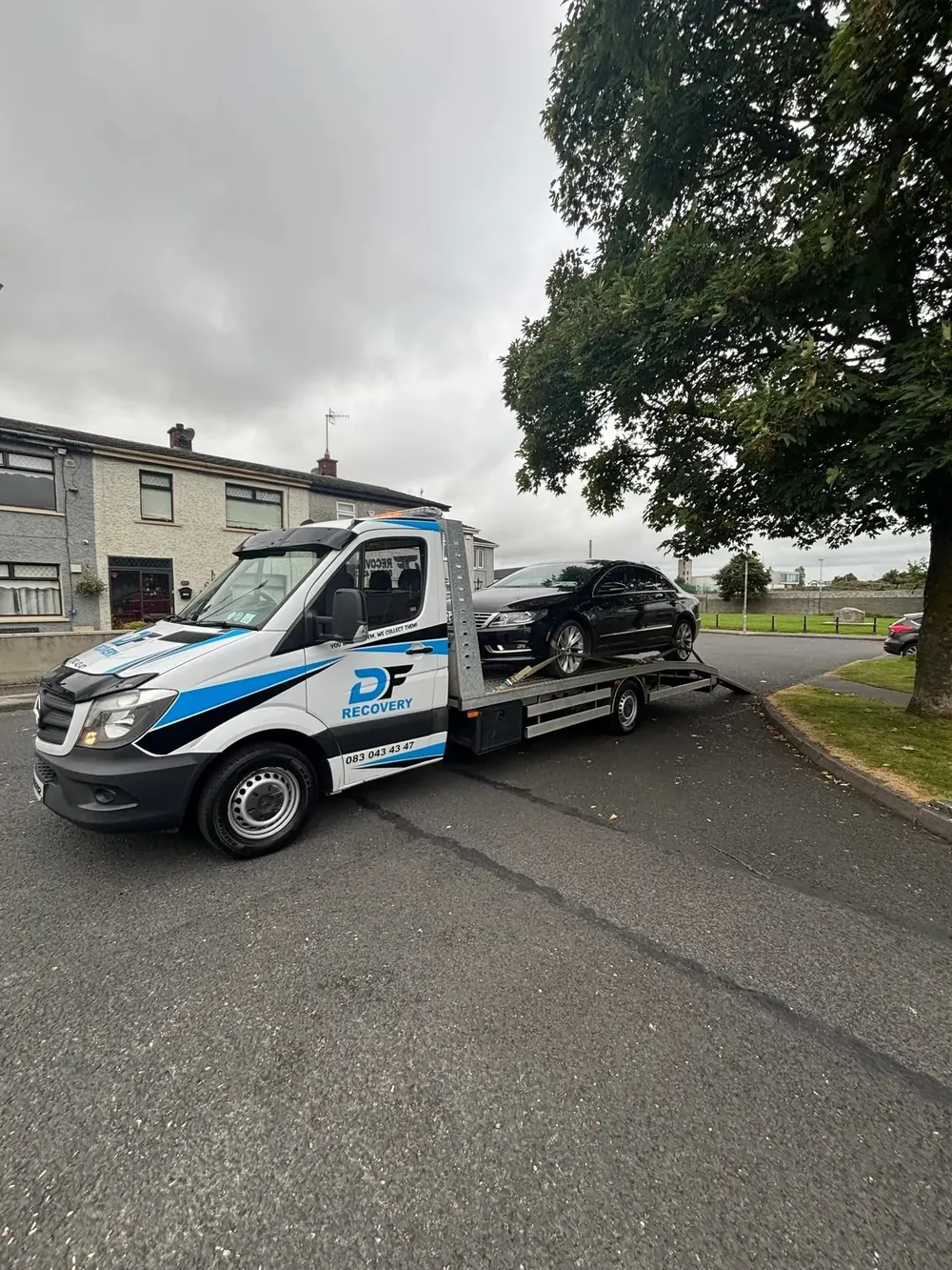 A vehicle being transported on a recovery truck