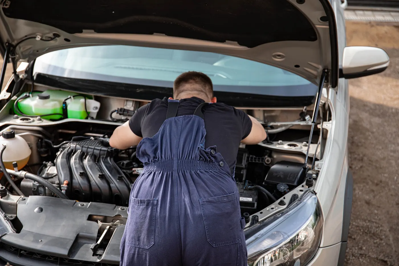 A mechanic working on a vehicle outdoors